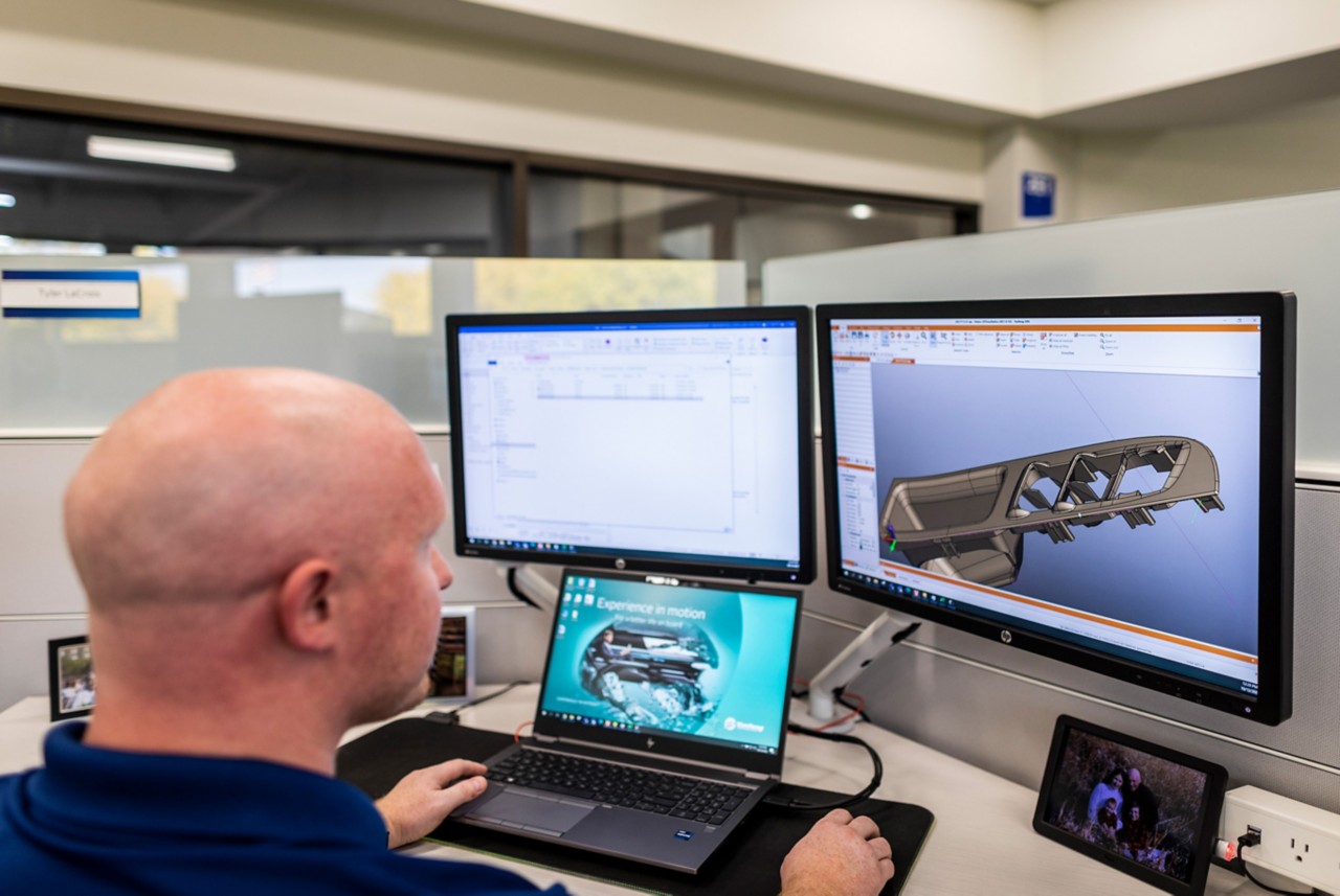 A man modeling in 3d a plastic auto-part on computer 