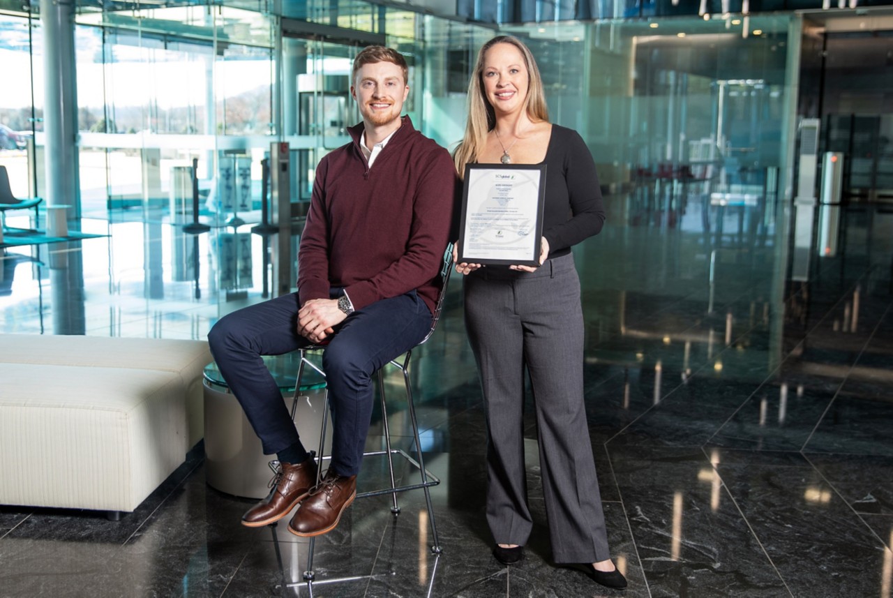 Jason Keller and Lacey Johnson pose with Eastman's Global Recycled Standard certification letter. 
