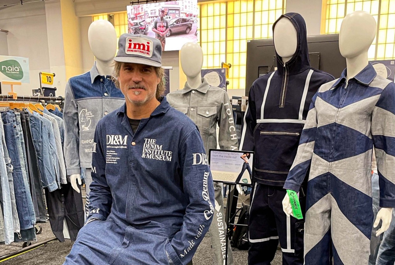 Loren Cronk wears a denim jumpsuit with The Denim Institute and Museum logo on it. 