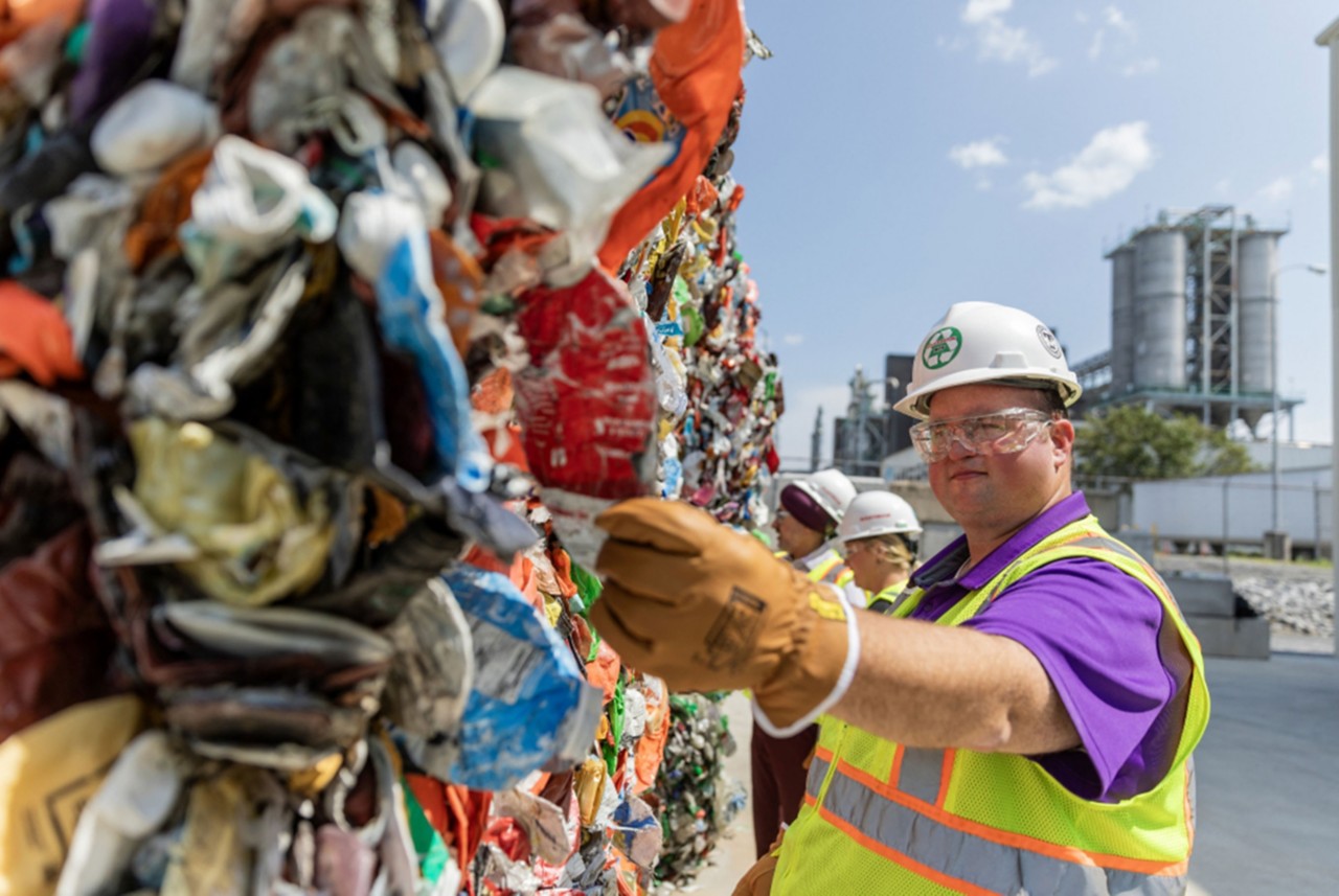 Spencer Tidwell holding up crushed plastic feedstock for Eastman’s methanolysis plant.  