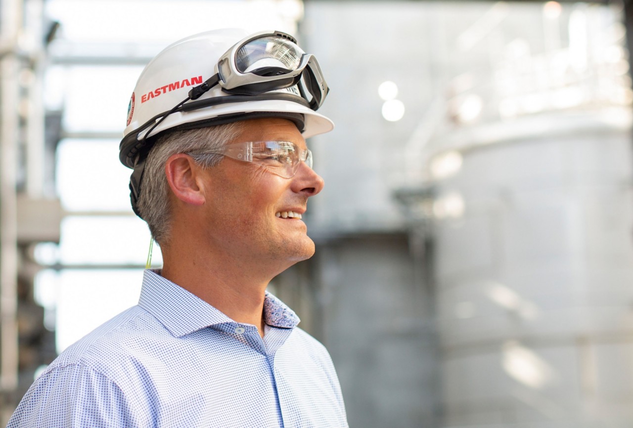 Man wearing a hard hat, lab coat and safety google. 